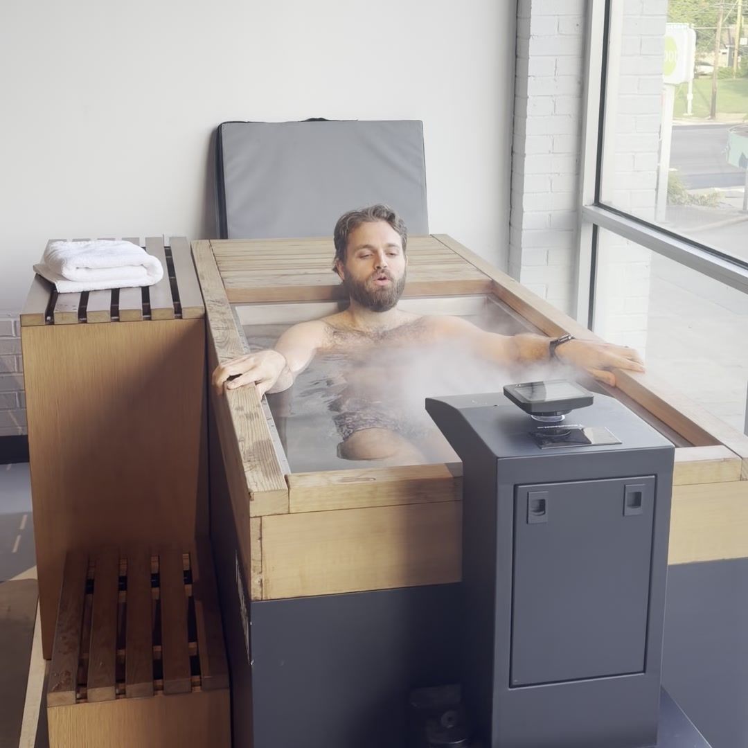 Member settled to the shoulders in a cold plunge, breathing slowly