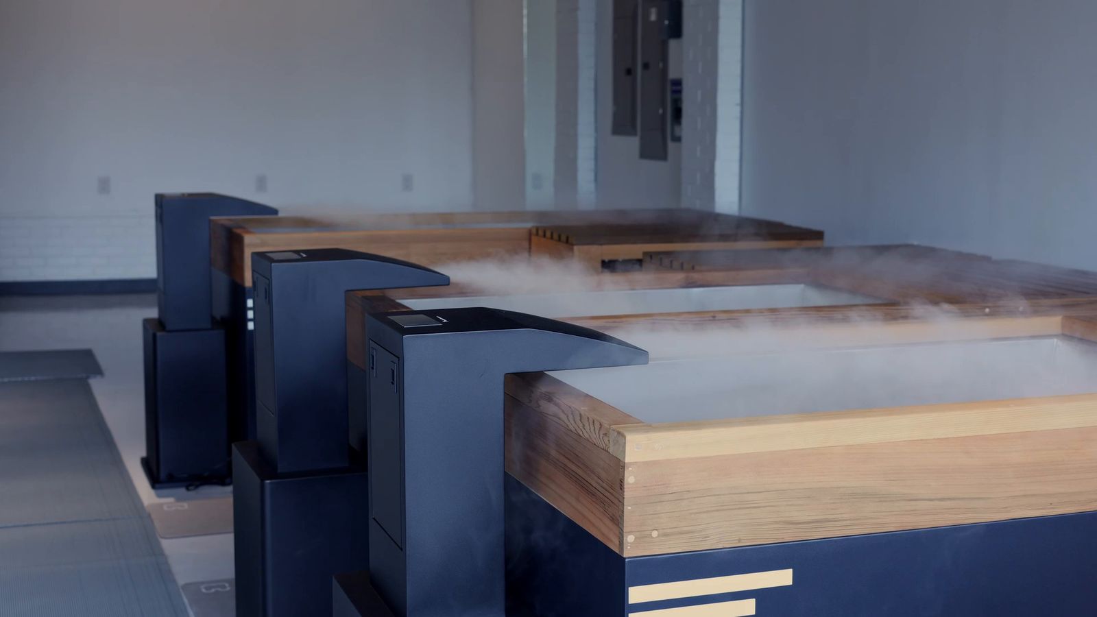 Three cold plunge tubs with cold mist rising off fresh water